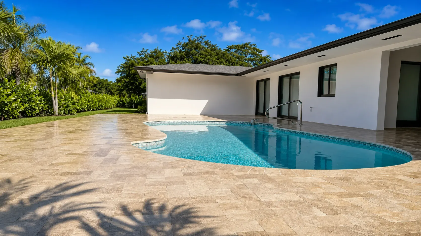 Travertine pool deck with artificial turf in Boynton Beach